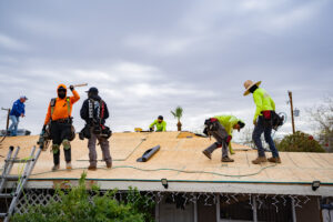 Roofing crew working on home roof installation in Arizona